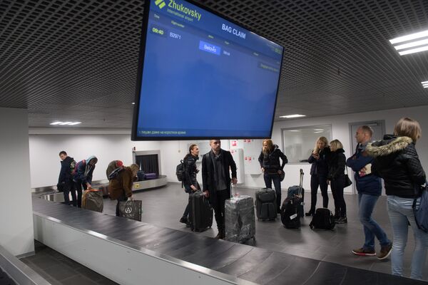 Пассажиры на пункте выдачи багажа в Международном аэропорту Жуковский