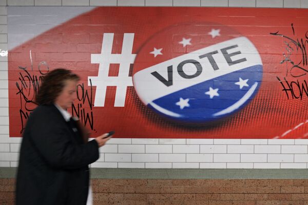Прохожая у плаката, посвященного голосованию на выборах президента США, в Нью-Йорке