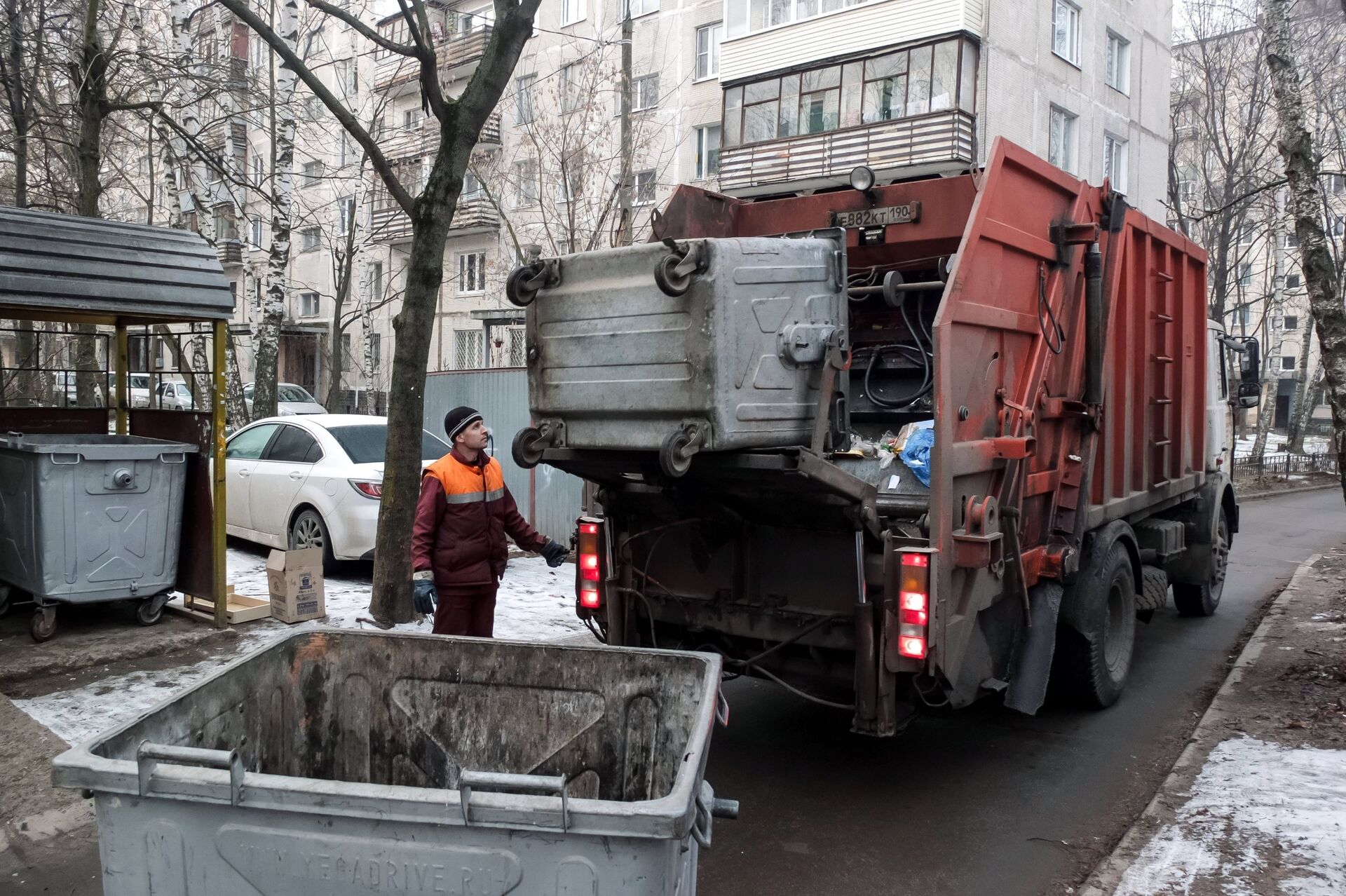  Сотрудник коммунальных служб выгружает мусор из контейнера в мусоровоз - ПРАЙМ, 1920, 26.04.2021