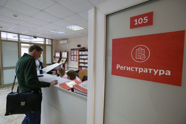 %Посетитель у регистрационного стола в поликлинике №180 в Москве
