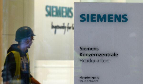 Рабочий у входа в штаб-квартиру компании Siemens в Мюнхене, Германия