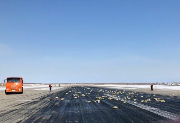 Взлетно-посадочная полоса аэропорта «Якутск» с рассыпанным грузом из самолёта Ан-12. 15 марта 2018