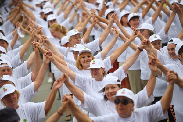 Участники массового флешмоба по зумбе в рамках проведения танцевального марафона Московское долголетие в парке Сокольники в Москве
