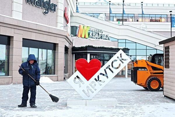 Работник коммунальной службы убирает снег в 130-м квартале Иркутска