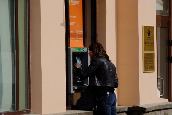 Девушка у банкомата Сбербанка.