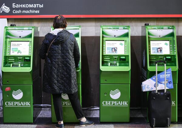 Женщина возле банкоматов на улице Москвы