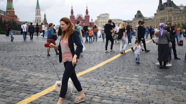 Люди гуляют по Красной площади в Москве.