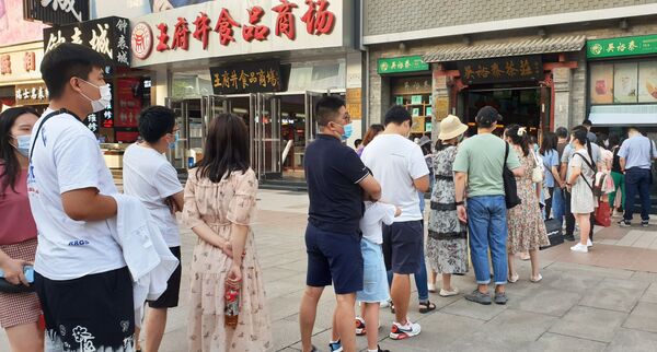 Горожане стоят в очереди на улице в Пекине