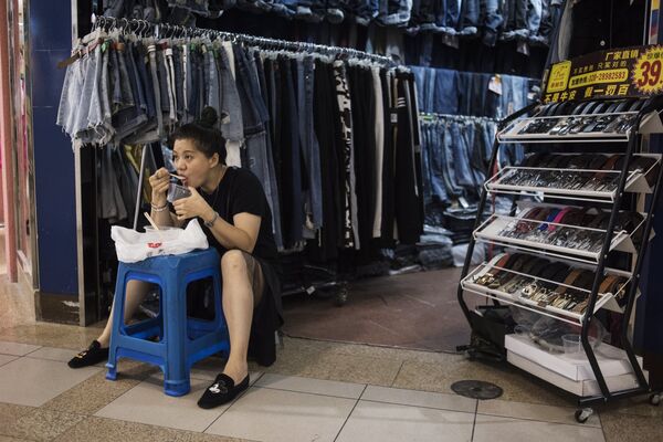 Продавщица одежды на китайском рынке во время обеда