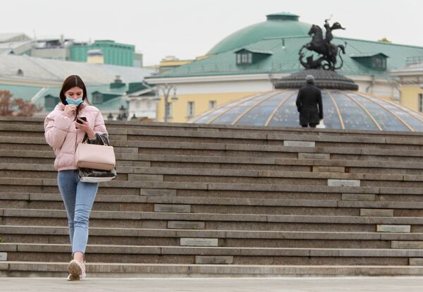  Девушка в защитной маске на Манежной площади в Москве.