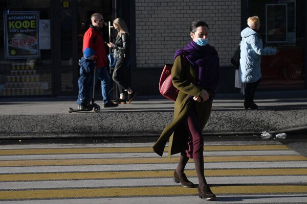  Женщина в защитной маске на улице в Москве