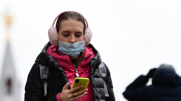 Девушка в маске со смартфоном