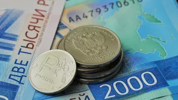 Монета номиналом 1 рубль и банкноты номиналом 2000 рублей