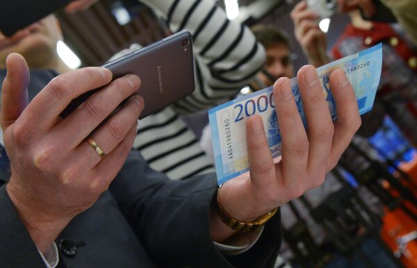 Смартфон и купюра достоинством в 2000 рублей.