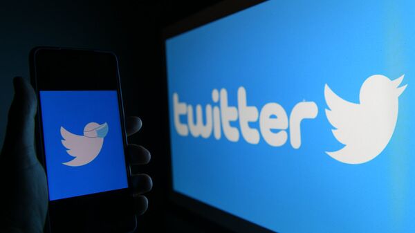 Логотип социальной сети Twitter на экранах мобильного телефона и компьютера