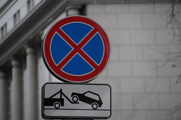 Дорожные знаки Остановка запрещена и Работает эвакуатор на одной из улиц в Москве