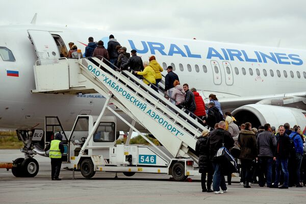Пассажиры поднимаются по трапу в самолет авиакомпании Ural Airlines в аэропорту Новый в Хабаровске.