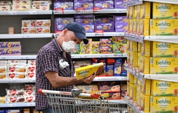 Покупатель выбирает товар в бакалейном отделе гипермаркета Ашан в Москве