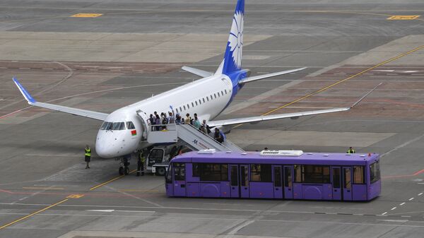 Пассажиры поднимаются по трапу на борт самолета белорусской авиакомпании Белавиа в национальном аэропорту Минск.
