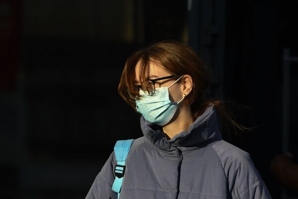 Женщина в маске на улице Москвы