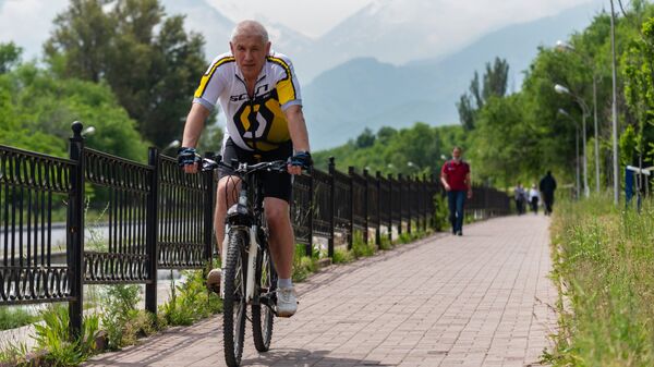 Мужчина на велосипеде в одном из парков в Алма-Аты.
