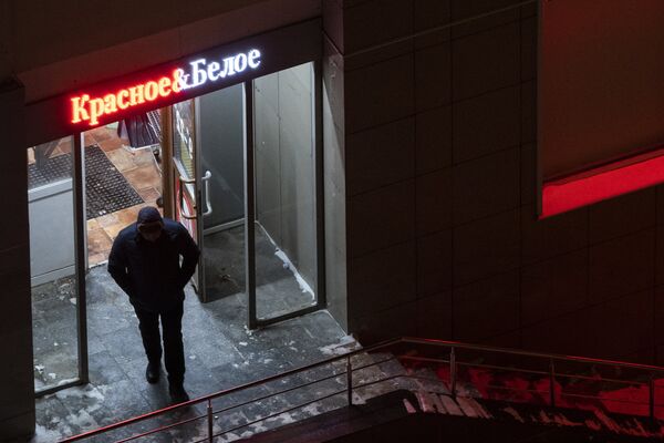 Мужчина выходит из магазина Красное & Белое в Москве