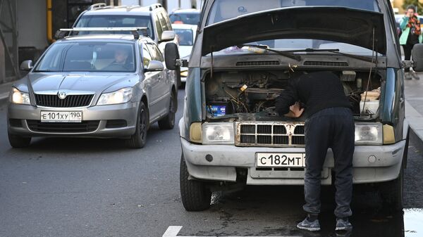 Мужчина пытается починить машину