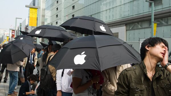 Люди стоят в очереди у Apple Store в Токио