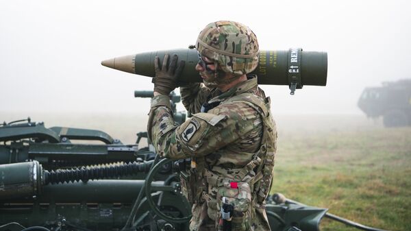 Американский солдат несет снаряд для гаубицы M777
